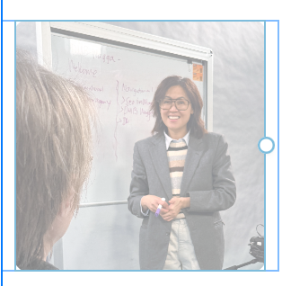 A professional woman presenting in front of a whiteboard during a workshop, representing website audit.
